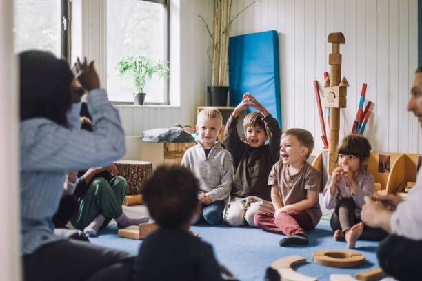 About Us A childcare educator engaging with children in a fun group activity at an early learning centre in Perth.